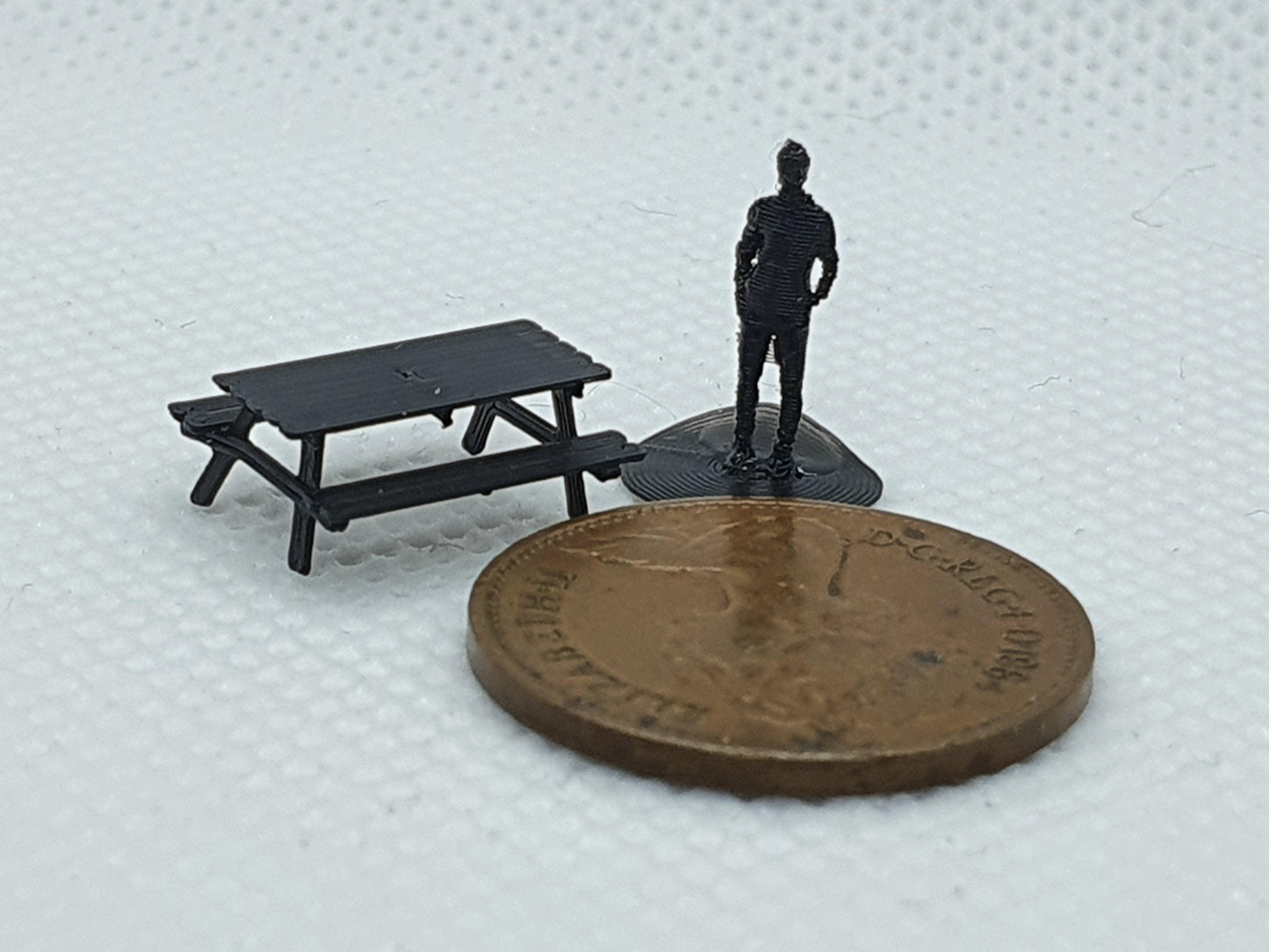 N gauge scale model picnic bench with N gauge figure and a penny for scale - Three Peaks Models