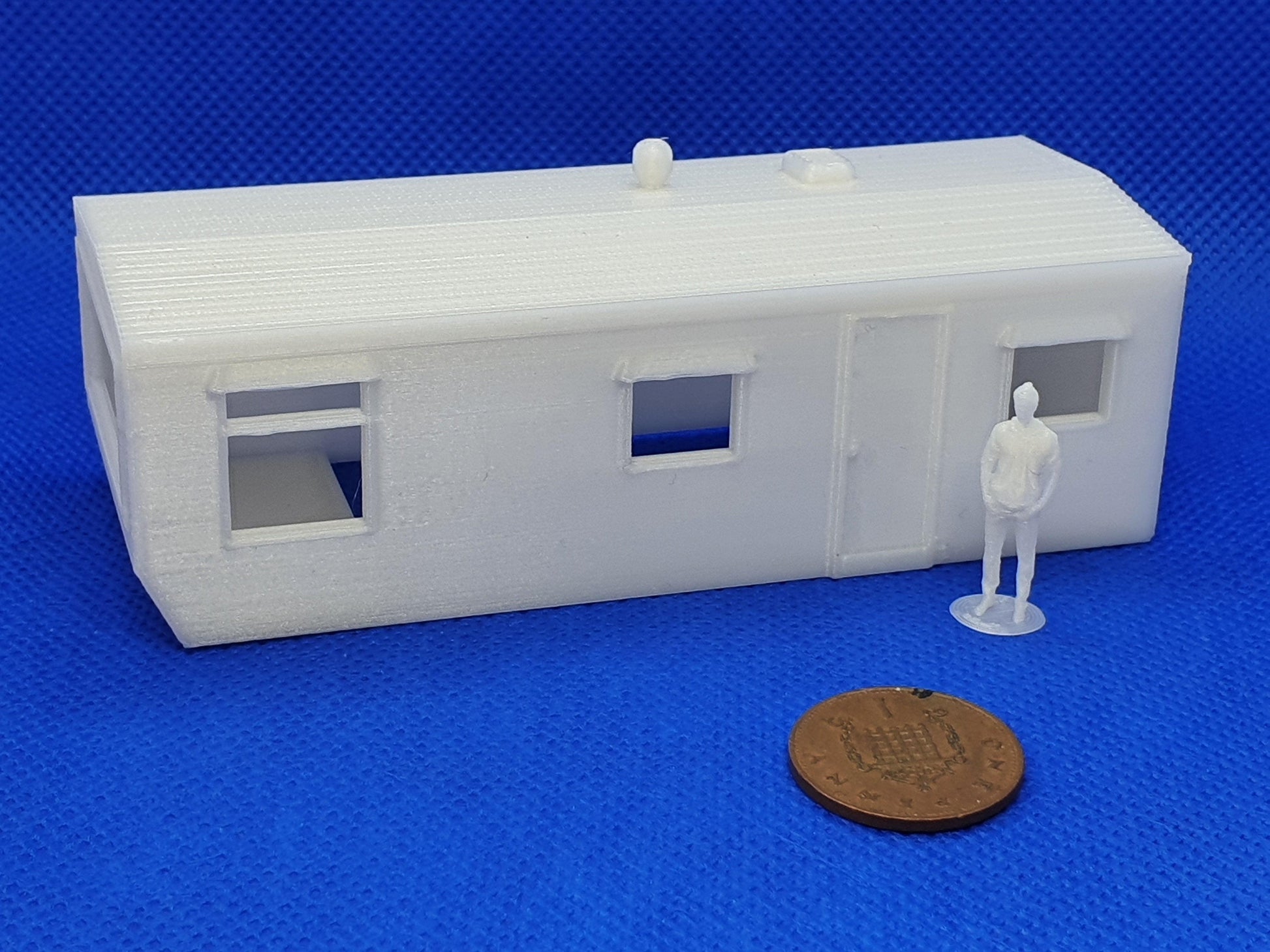 Static caravan OO gauge scale model - body, with person and penny alongside for scale - Three peaks models